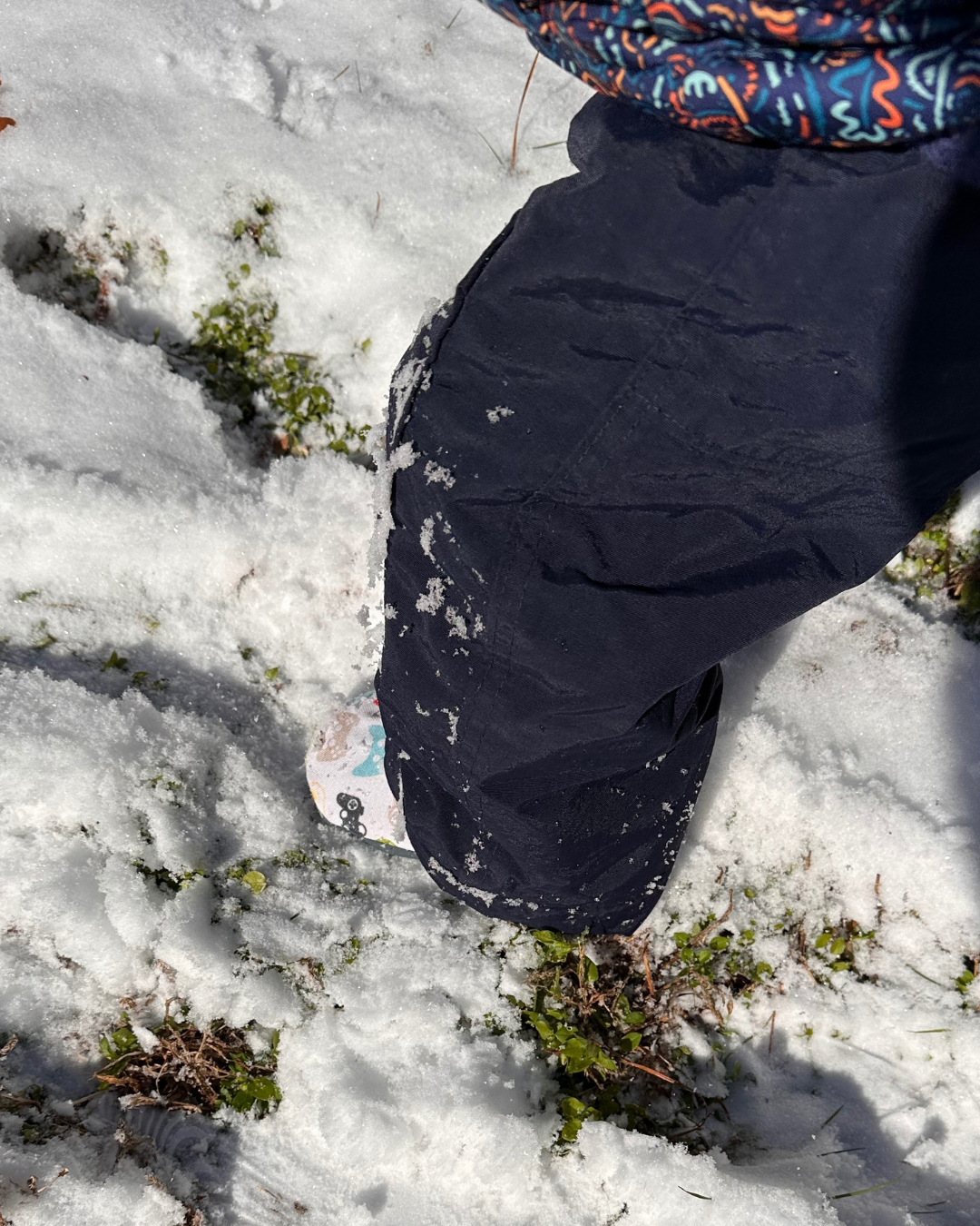 Baby wearing limited edition Game Day Cabooties eco-canvas baby shoes in the snow